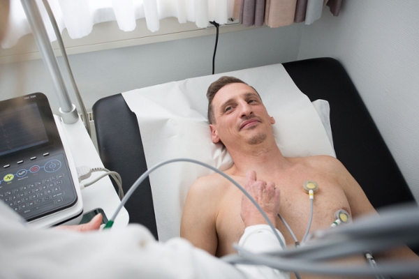 Mann mit EKG-Paddles auf dem Oberkörper  Mann mit EKG-Paddles auf dem Oberkörper