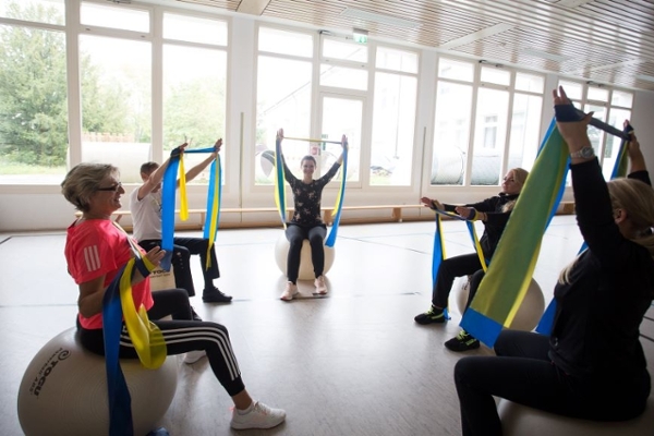 Personengruppe auf Pezzibällen sitzend mit Therapiebändern Personengruppe auf Pezzibällen sitzend mit Therapiebändern